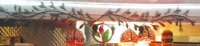 Over the kitchen was a metal garland, a glass parrot, some tiffany lamps, and a statue of a cheeseburger. I just, I just loved this place so much.